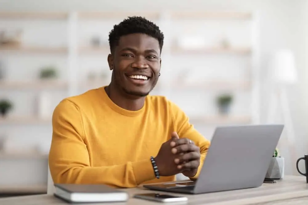 Man smiling while working on laptop